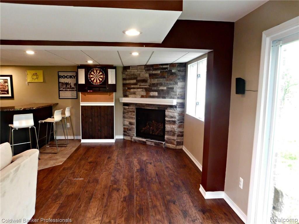 6750 Cuthbert Road White Lake, MI 48386 - Photo 30 of 40 gas fireplace with stacked stone and gorgeous laminate flooring complete this finished lower level