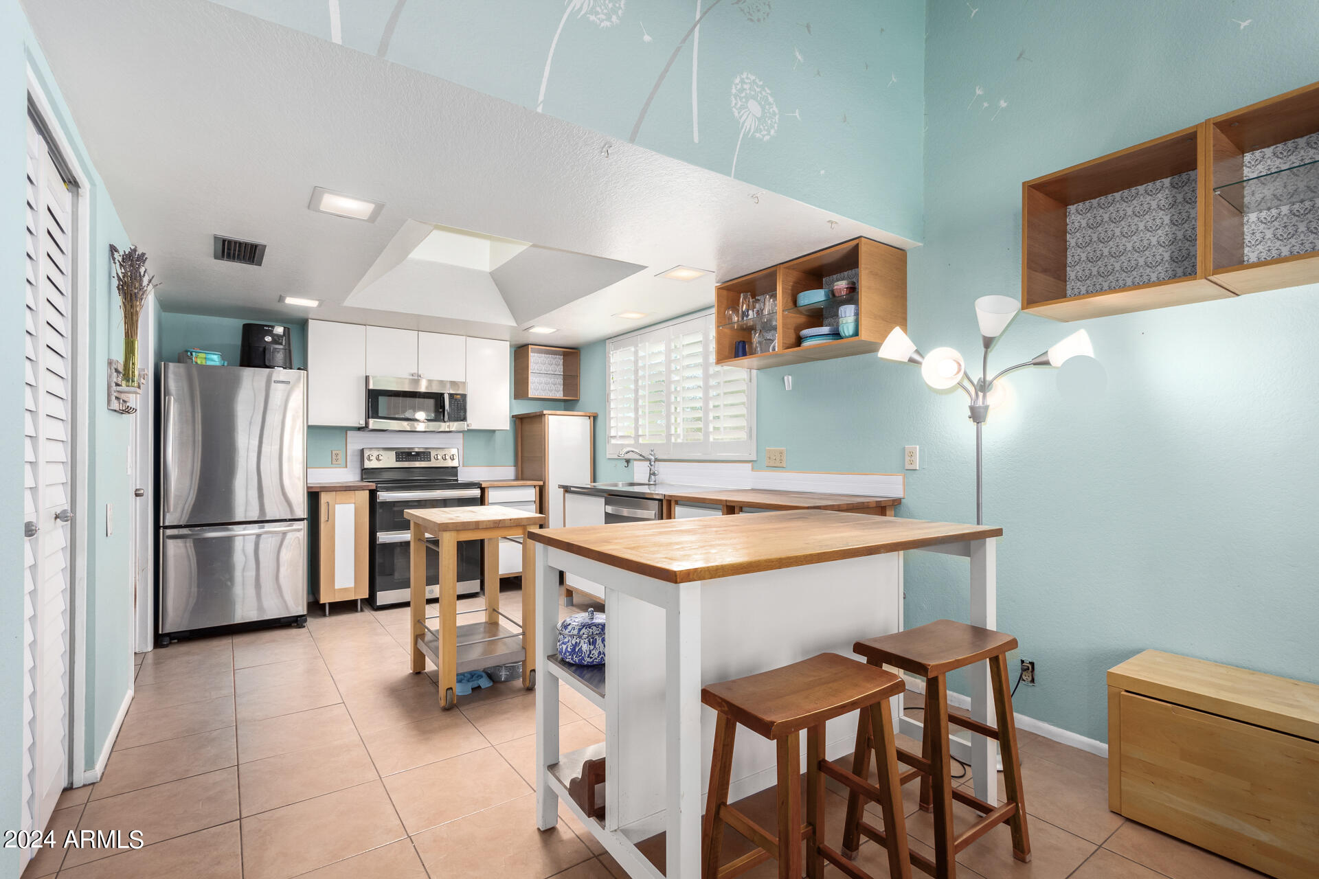 6516 West Mountain View Road Glendale, AZ 85302 - Photo 17 of 35 a kitchen with stainless steel appliances a stove a refrigerator and a refrigerator