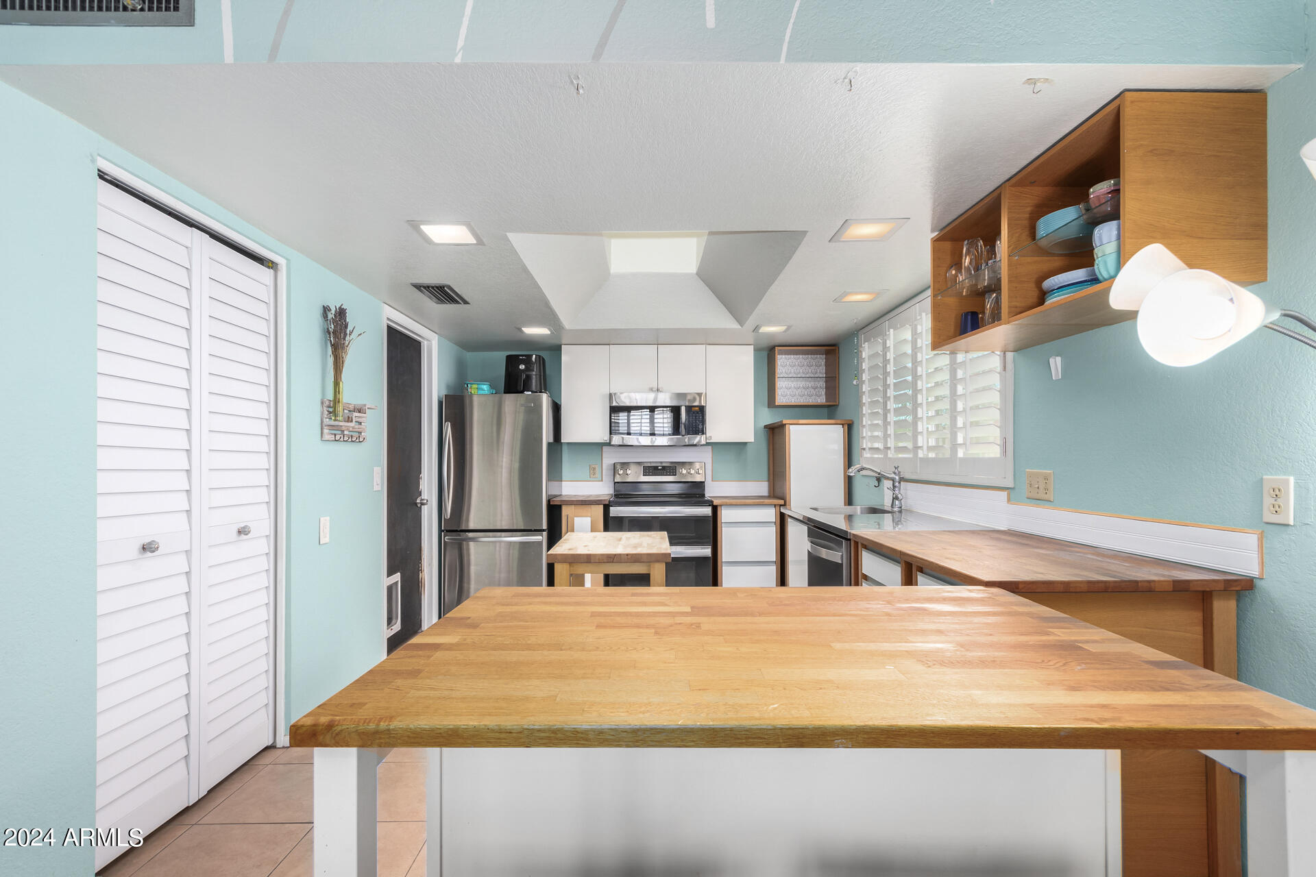6516 West Mountain View Road Glendale, AZ 85302 - Photo 18 of 35 a kitchen with stainless steel appliances granite countertop a sink and a refrigerator
