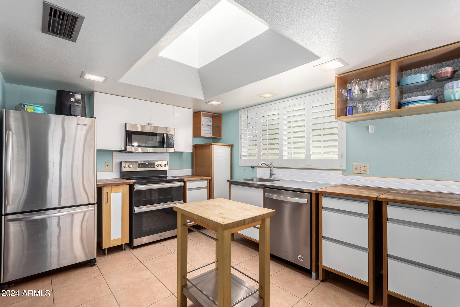 6516 West Mountain View Road Glendale, AZ 85302 - Photo 19 of 35 a kitchen with stainless steel appliances a stove a sink refrigerator and microwave