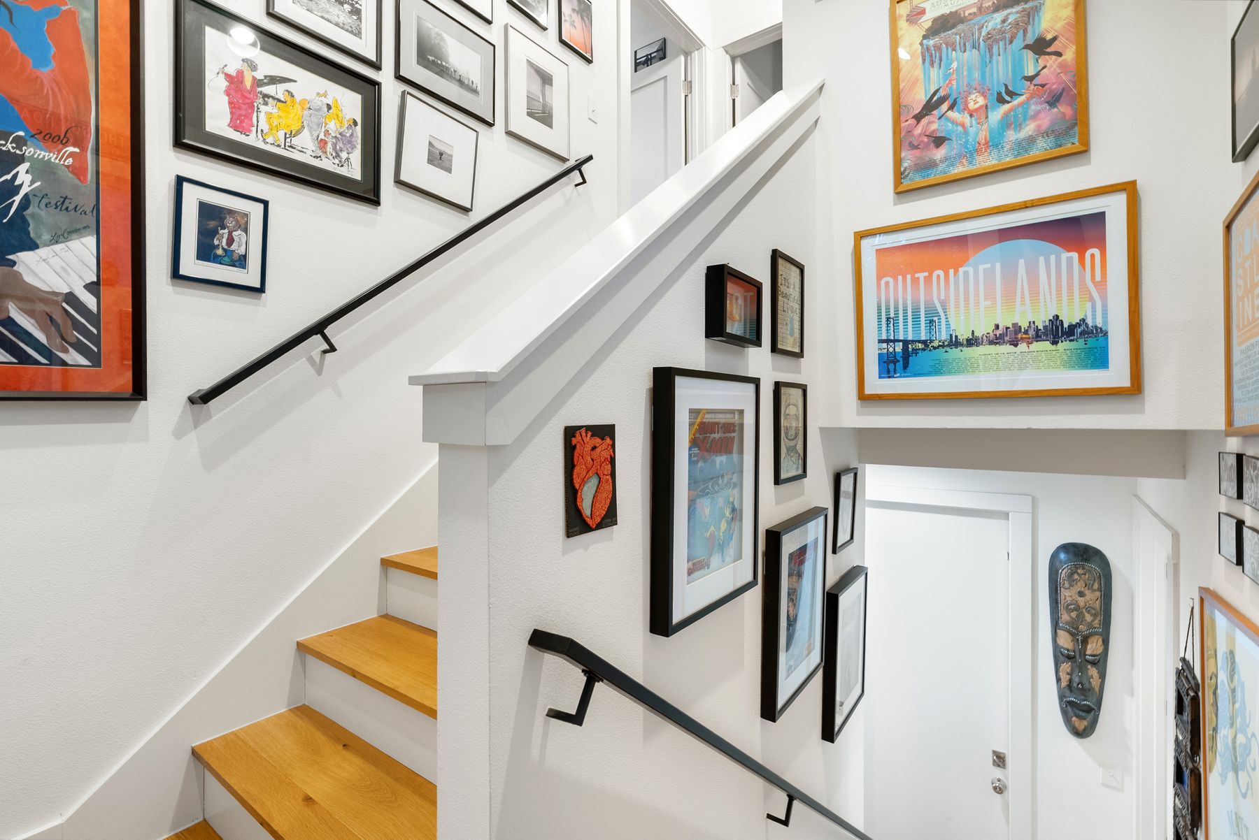 1709 Perez Street, Unit 2 Austin, TX 78721 - Photo 20 of 33 Clean lines and a striking gallery wall define this inviting stairwell, showcasing natural wood treads.