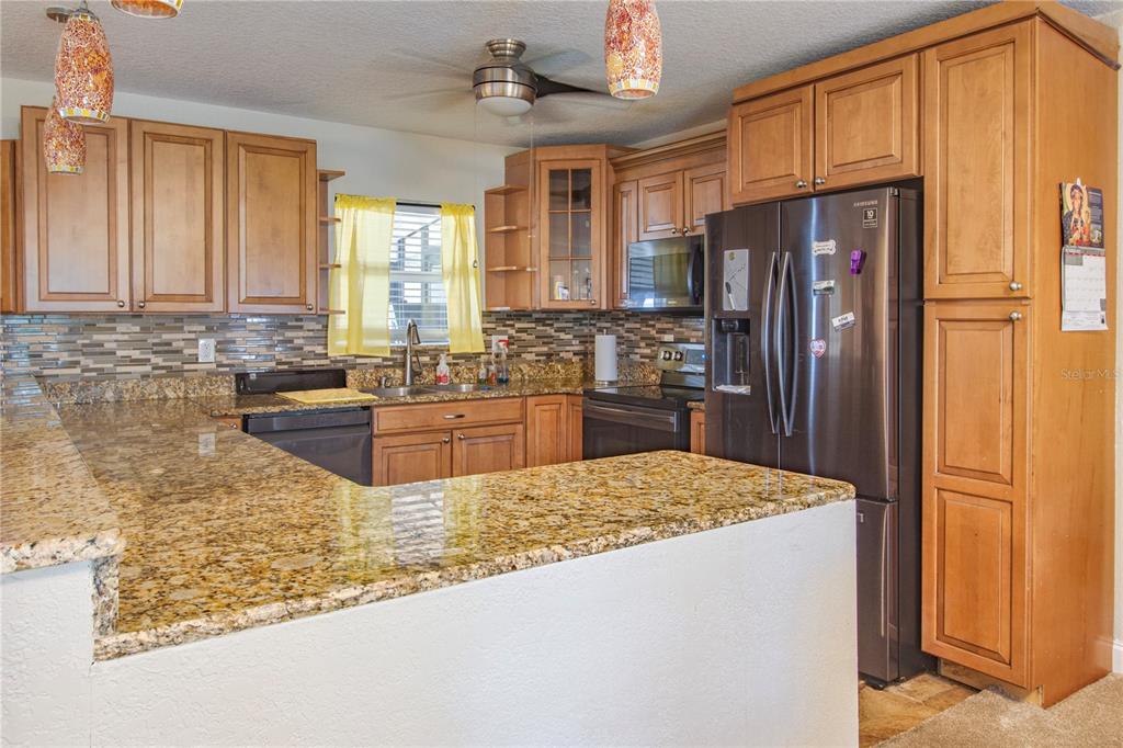 7367 Gates Circle Spring Hill, FL 34606 - Photo 6 of 31 a kitchen with stainless steel appliances granite countertop a refrigerator a stove and a sink