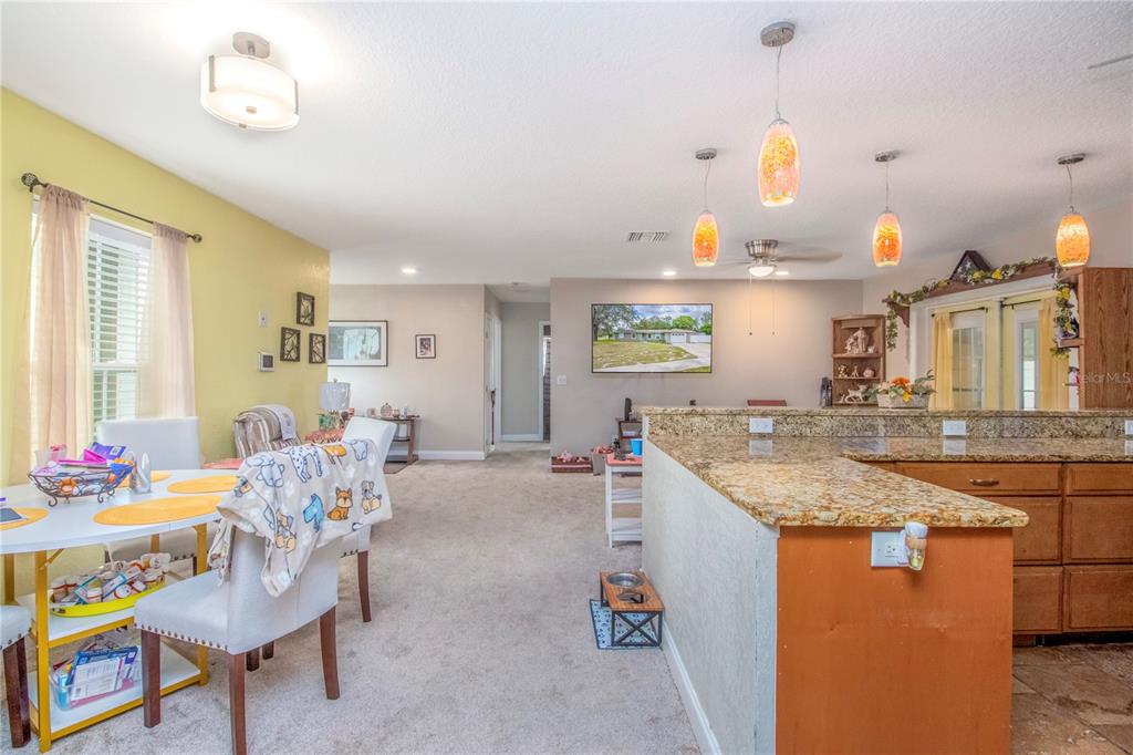 7367 Gates Circle Spring Hill, FL 34606 - Photo 10 of 31 a kitchen with kitchen island stainless steel appliances a sink and living room view