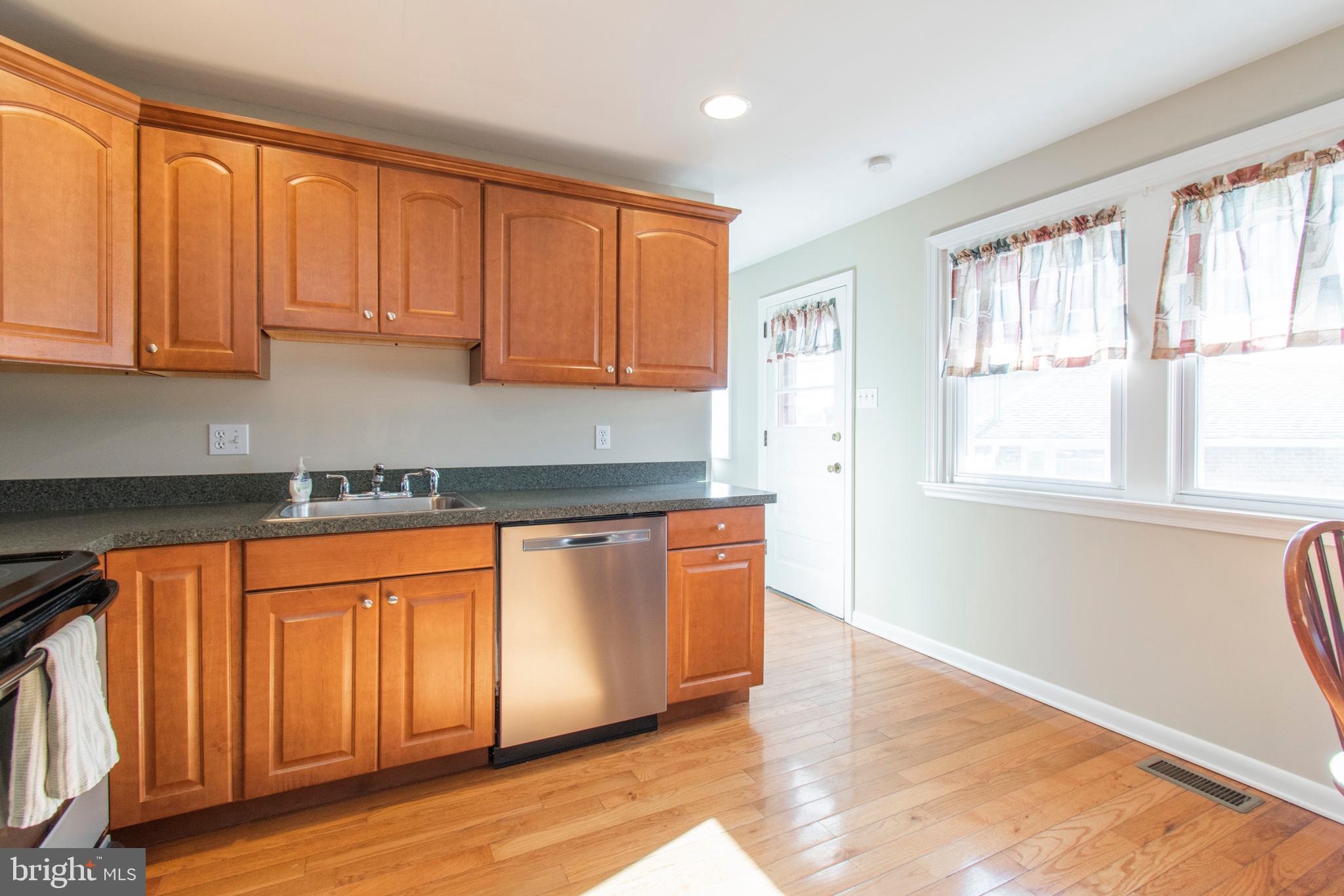 2333 Poplar Road Havertown, PA 19083 - Photo 14 of 38 a large kitchen with granite countertop wooden cabinets a sink and a large window