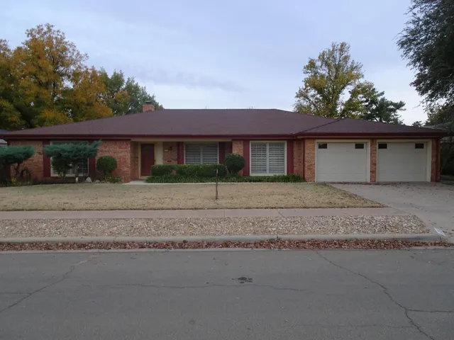 a front view of a house with a yard and potted plants