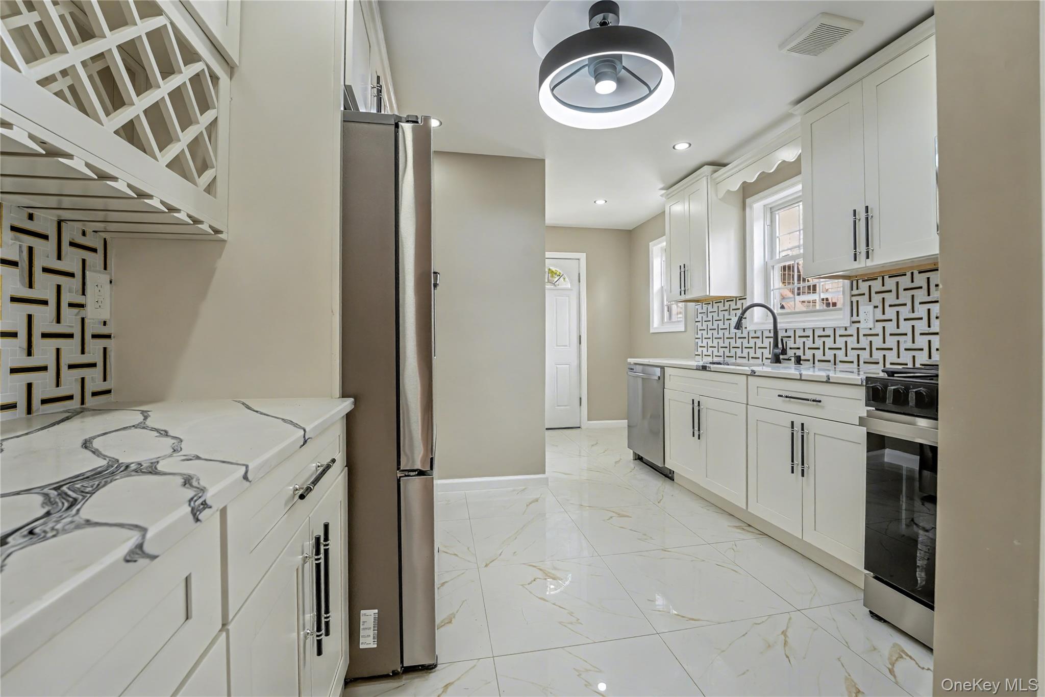104-40 194th Street Queens, NY 11412 - Photo 6 of 18 a kitchen with a stove a sink and a refrigerator