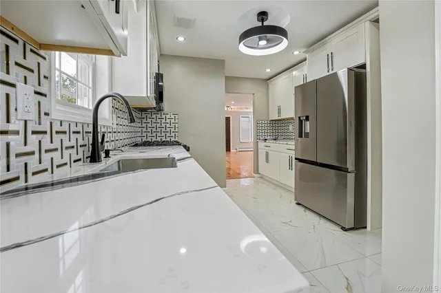 a kitchen with stainless steel appliances granite countertop a refrigerator and a stove top oven