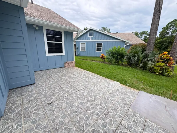 a front view of a house with a yard and potted plants