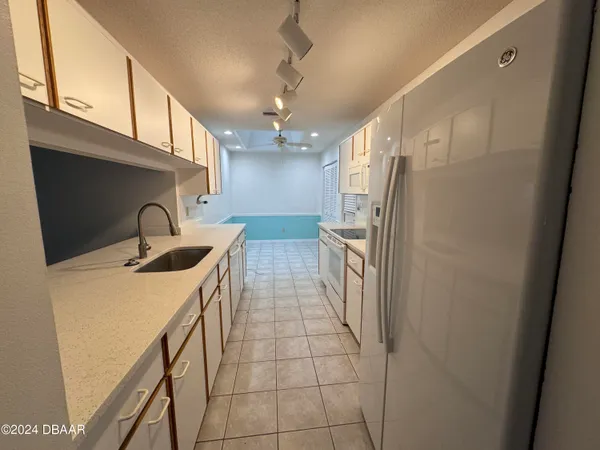 a kitchen with stainless steel appliances granite countertop a sink a refrigerator and a stove