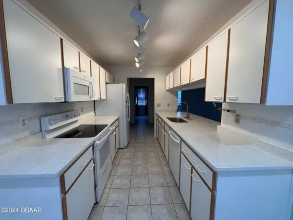 a kitchen with stainless steel appliances granite countertop a sink a stove top oven a counter space and cabinets