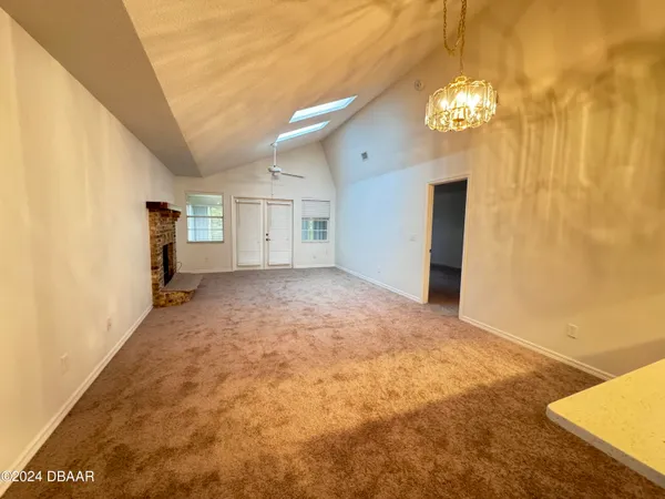 an empty room with windows and fireplace