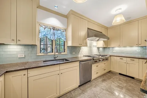 a kitchen with granite countertop white cabinets white appliances and a sink