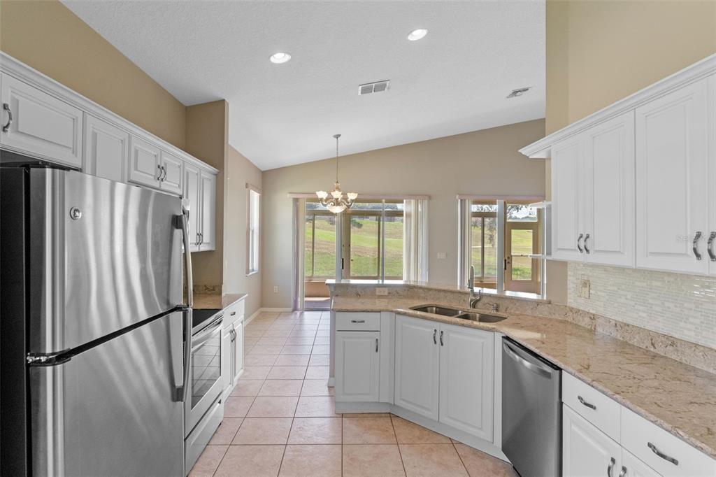 890 Summit Greens Boulevard Clermont, FL 34711 - Photo 13 of 62 a kitchen with a refrigerator and a sink
