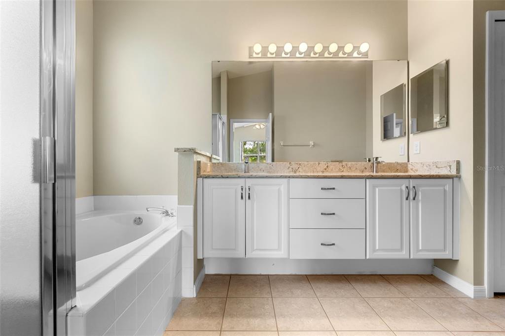 890 Summit Greens Boulevard Clermont, FL 34711 - Photo 24 of 62 a bathroom with a granite countertop sink mirror and bathtub