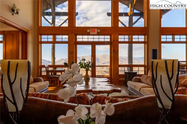 a living room with furniture and floor to ceiling windows