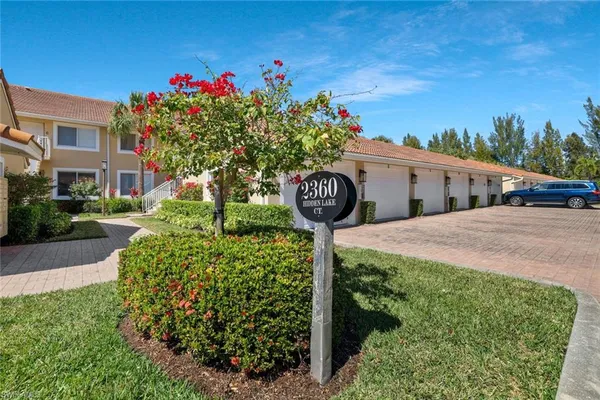 a front view of a house with yard and trees