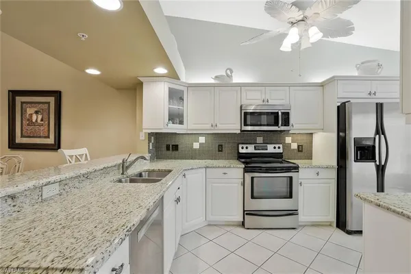 a kitchen with stainless steel appliances granite countertop a sink and a stove