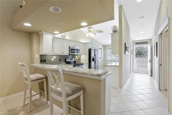 a kitchen with stainless steel appliances granite countertop a refrigerator and a stove top oven