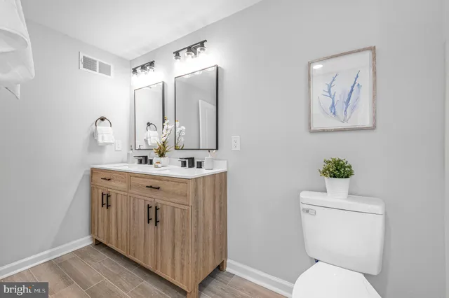 a bathroom with a toilet a sink and mirror