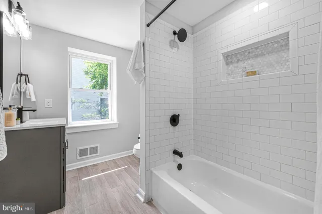 a bathroom with a bathtub a window and a shower
