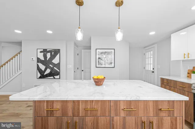 a kitchen with a sink a counter space and living room view
