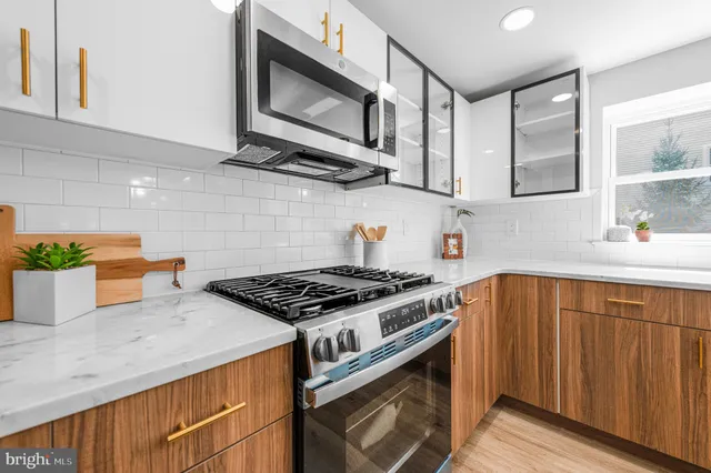 a kitchen with stainless steel appliances granite countertop a stove a sink and a microwave
