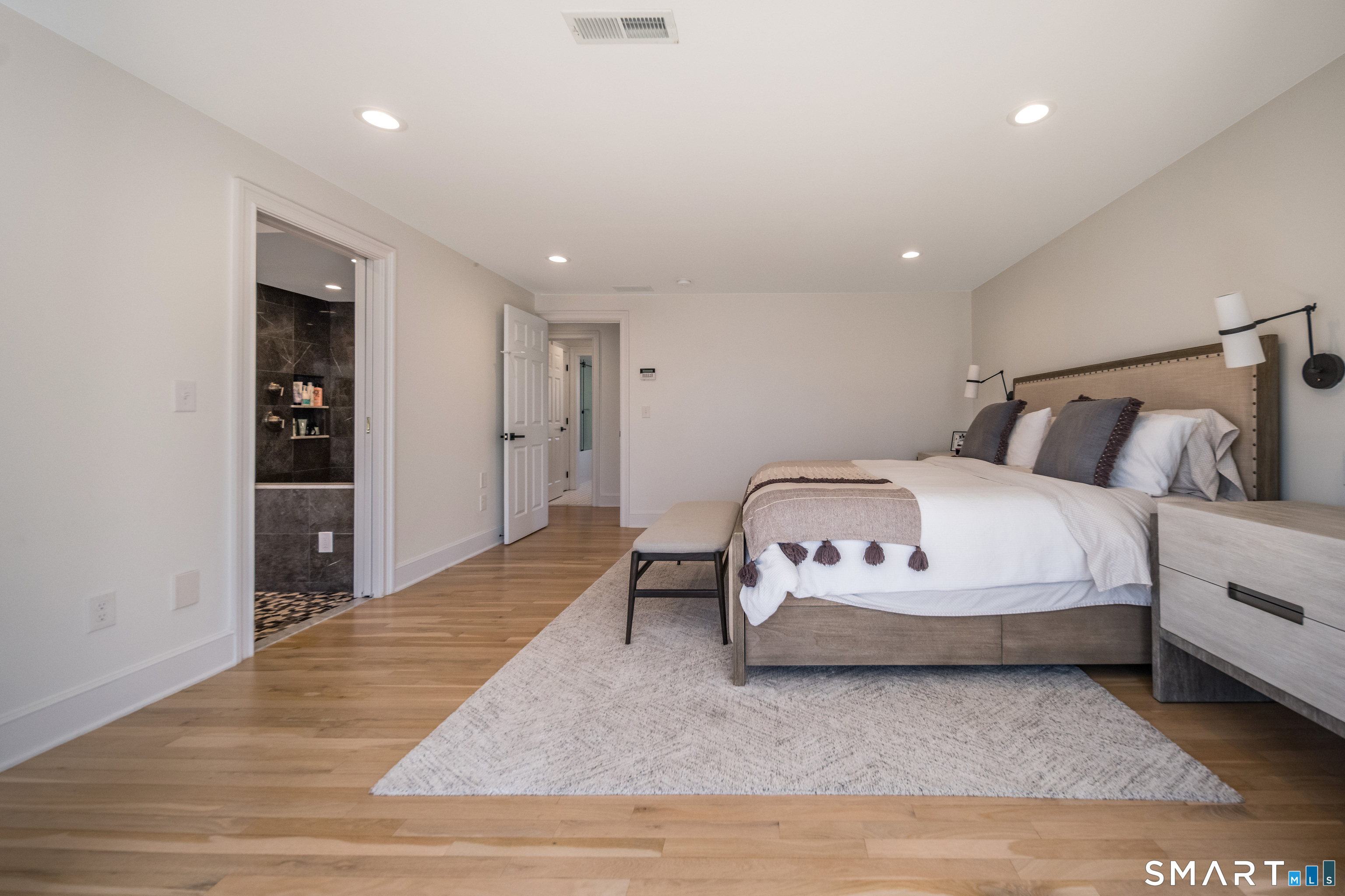 45 Island Avenue Madison, CT 06443 - Photo 20 of 38 a spacious bedroom with a bed and a table