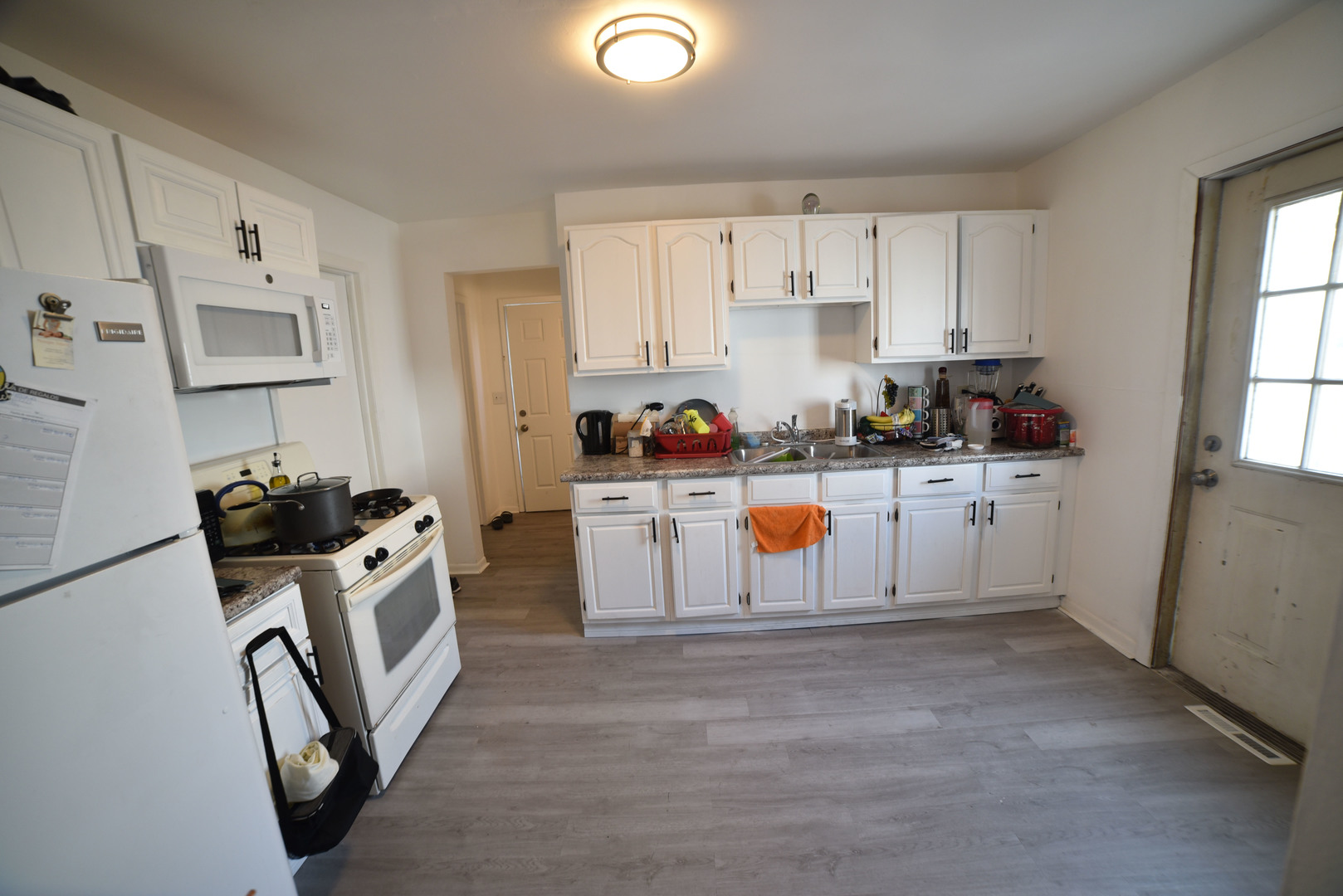 1809 Washington Street Waukegan, IL 60085 - Photo 5 of 16 a kitchen with white cabinets a sink stove and refrigerator