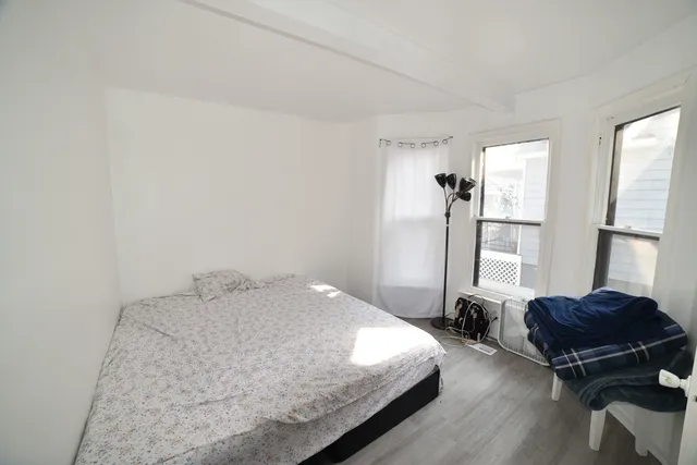 a bedroom with a bed and wooden floor