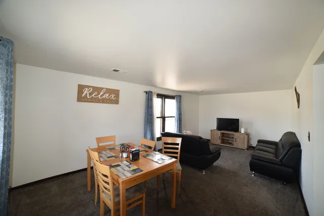 a work room with furniture a flat screen tv and a window
