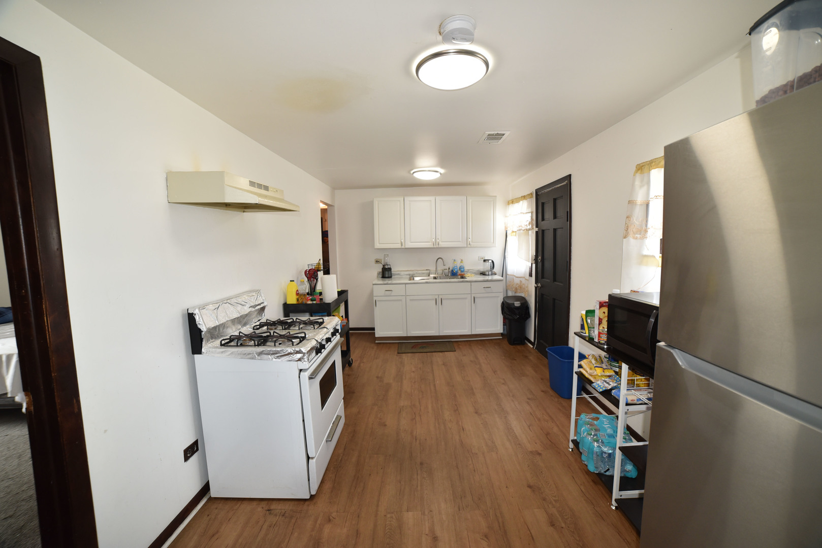 1809 Washington Street Waukegan, IL 60085 - Photo 10 of 16 a kitchen with a refrigerator a stove top oven a counter space and wooden floor