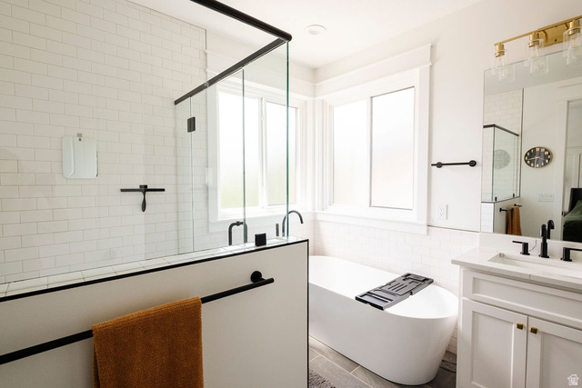 924 Country Lane Farmington, UT 84025 - Photo 28 of 91 Bathroom featuring a frameless glass shower enclosure with matte black trim, a freestanding soaking tub, a single vanity with a white countertop, a large mirror, and matte black fixtures