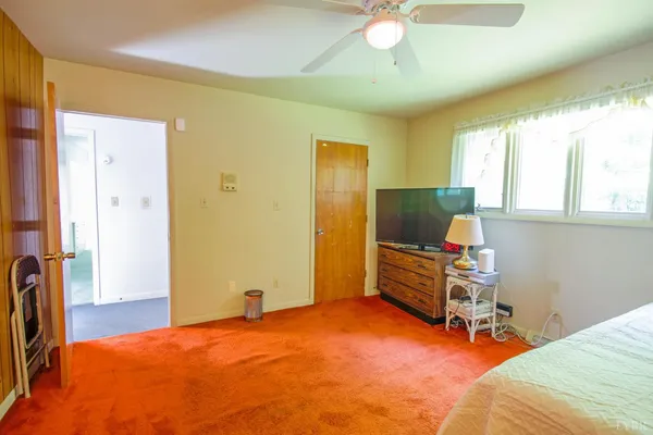 a bedroom with a bed and dresser with mirror