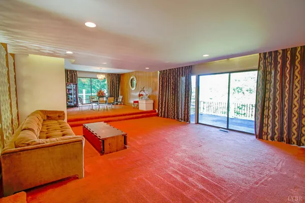 a dining room with furniture a chandelier and wooden floor