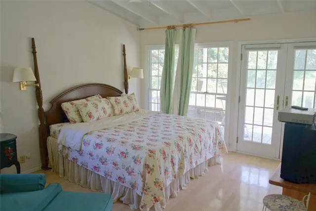 a bedroom with a bed and a flat tv screen on the dresser