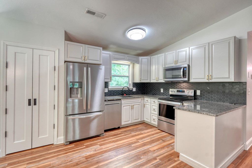 45 Mountain Stream Road Murphy, NC 28906 - Photo 15 of 33 a kitchen with white cabinets and stainless steel appliances