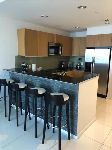 a kitchen with granite countertop a sink counter and chairs