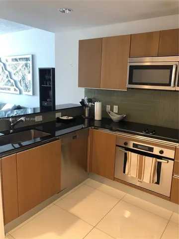 a kitchen with granite countertop a sink stove and microwave