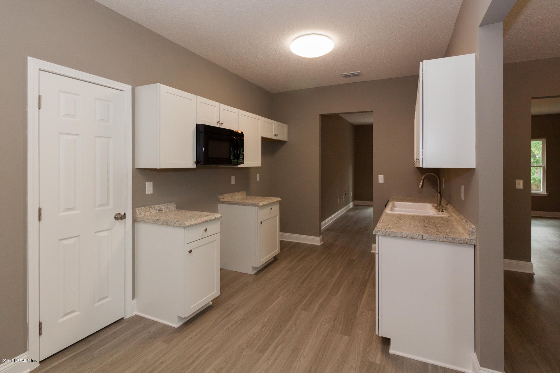 12879 Beaubien Road Jacksonville, FL 32258 - Photo 11 of 28 a kitchen with white cabinets and stainless steel appliances