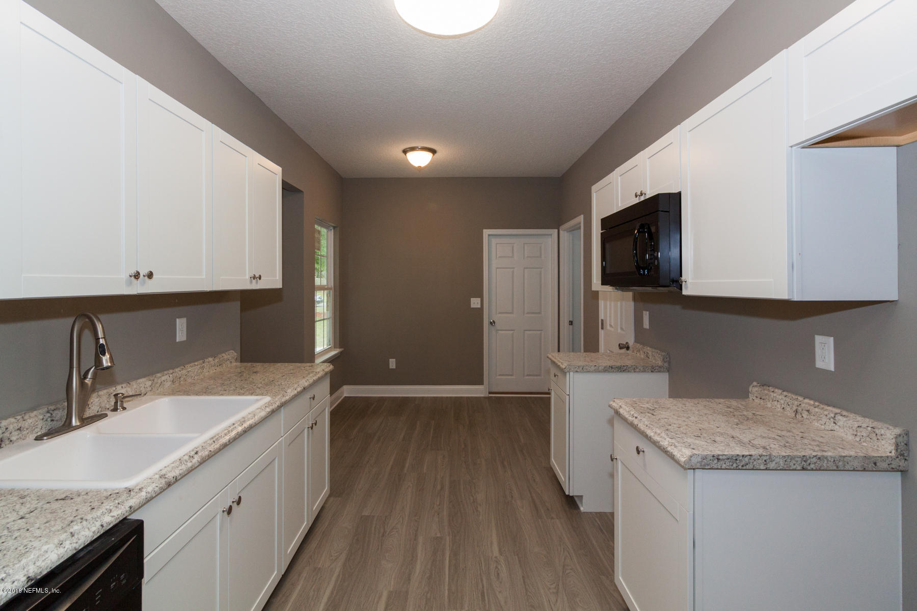 12879 Beaubien Road Jacksonville, FL 32258 - Photo 14 of 28 a bathroom with a granite countertop sink a large mirror and a wooden floor