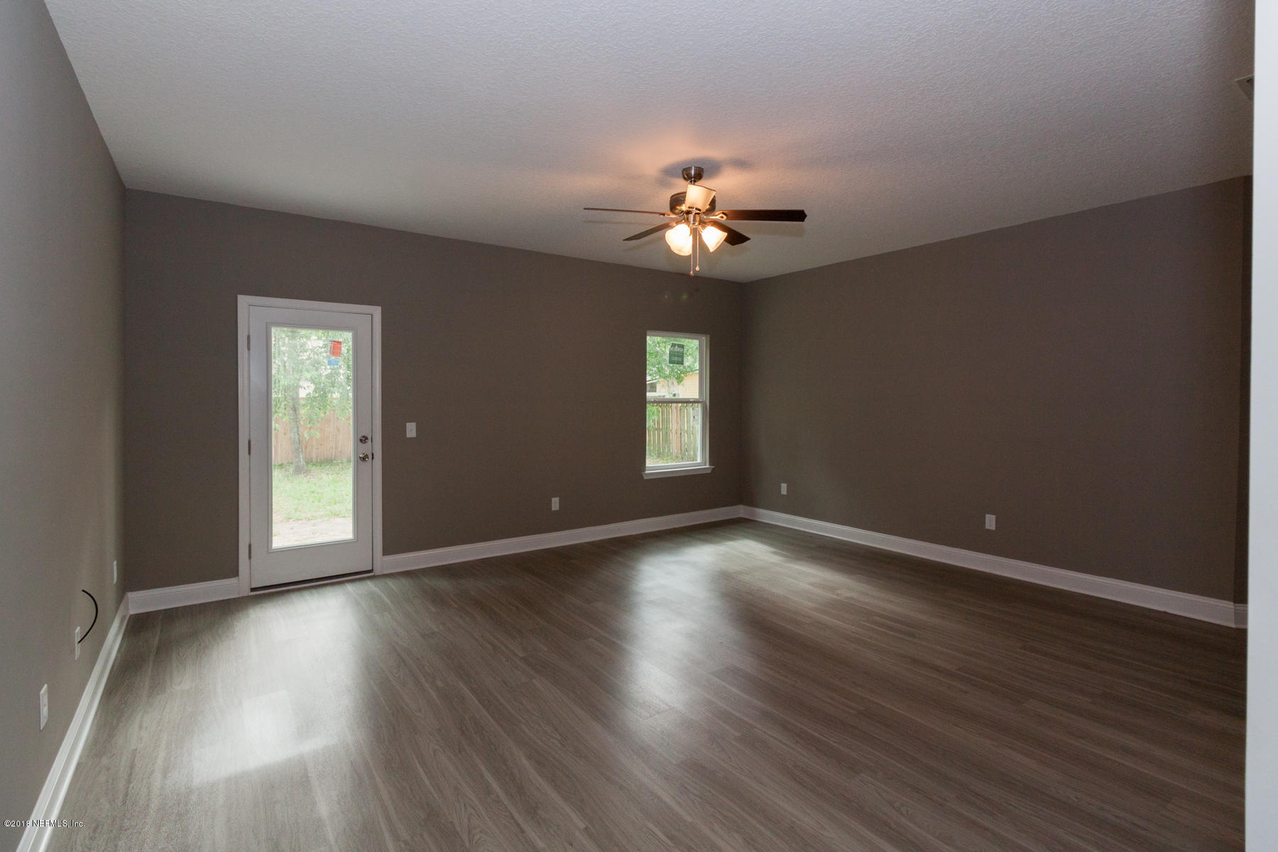 12879 Beaubien Road Jacksonville, FL 32258 - Photo 10 of 28 a view of an empty room with a window and wooden floor