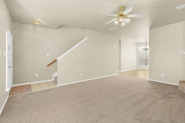 a view of an empty room with a ceiling fan