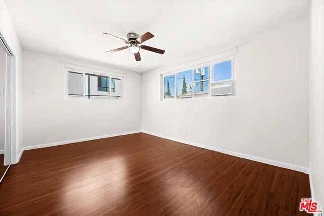 a view of an empty room with wooden floor