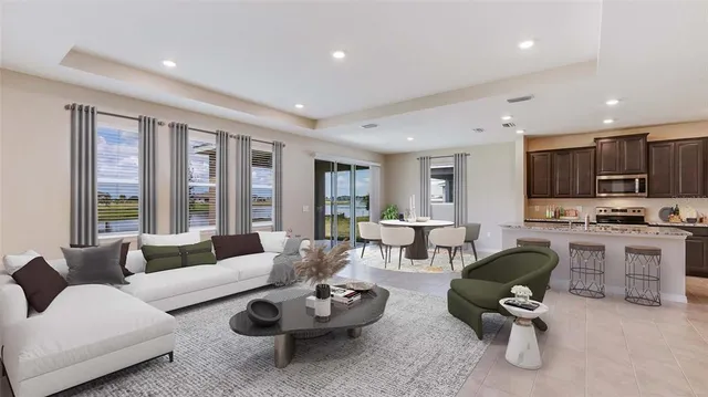 a living room with furniture kitchen view and a large window
