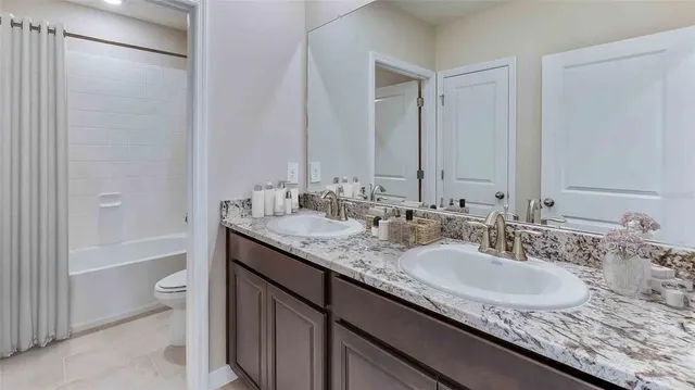 a bathroom with a granite countertop sink a toilet and shower