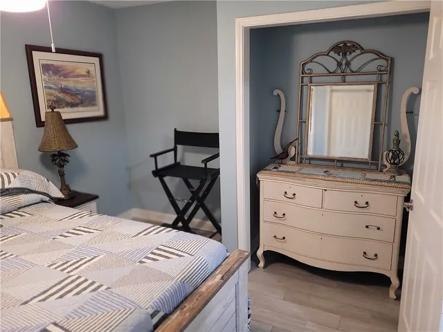 a bedroom with a bed and a mirror on the dresser