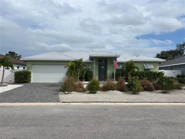 front view of house with a yard and potted plants