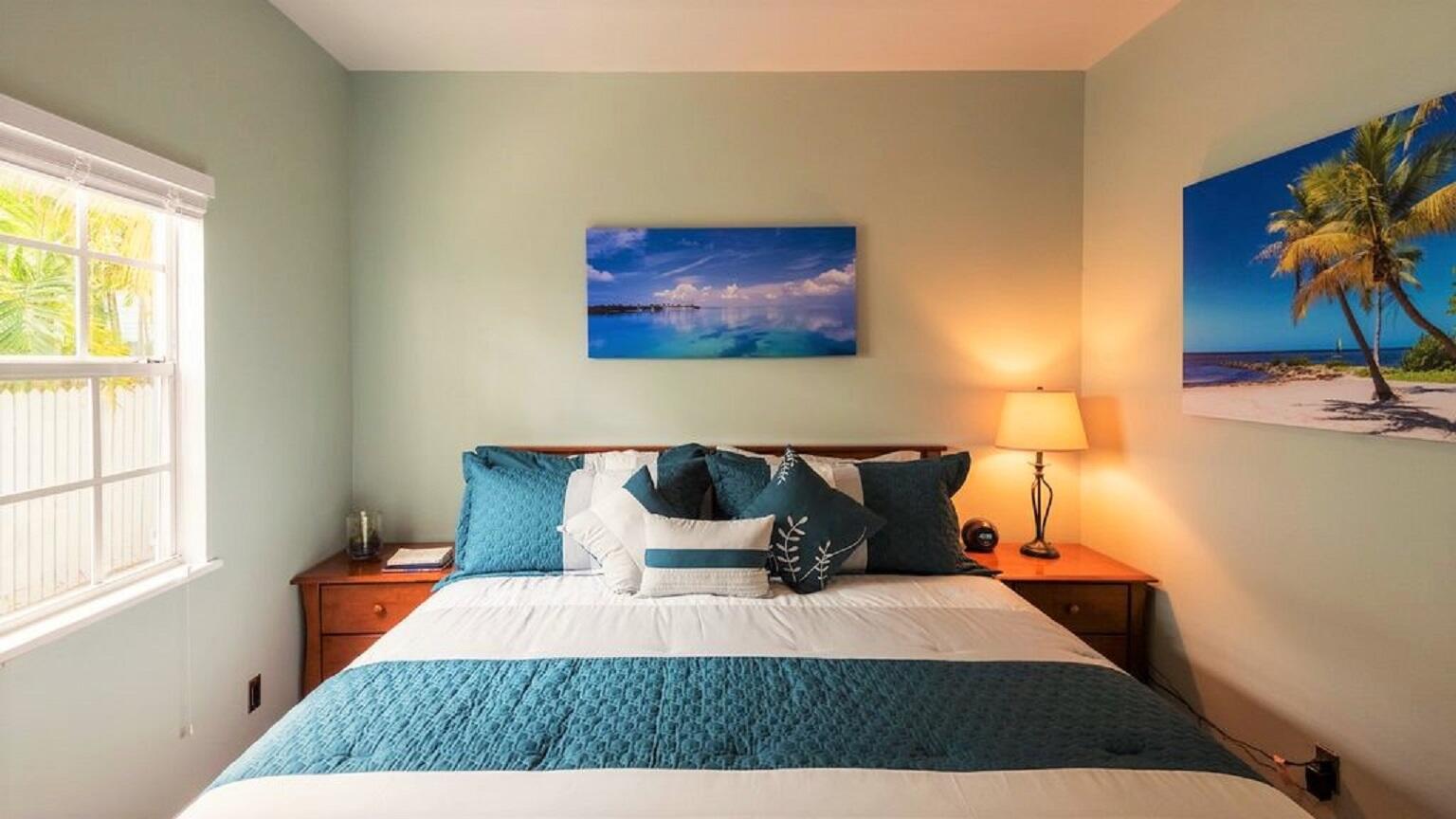 906 Truman Avenue, Unit 1 Key West, FL 33040 - Photo 7 of 12 a bedroom with a bed and painting on the wall