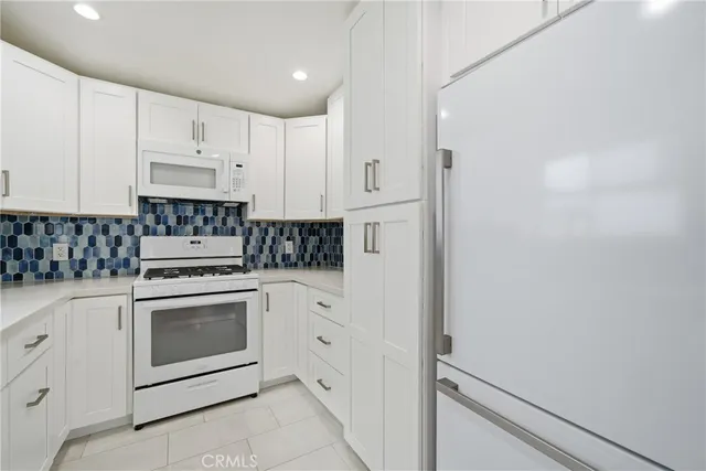 a kitchen with white cabinets stainless steel appliances and sink