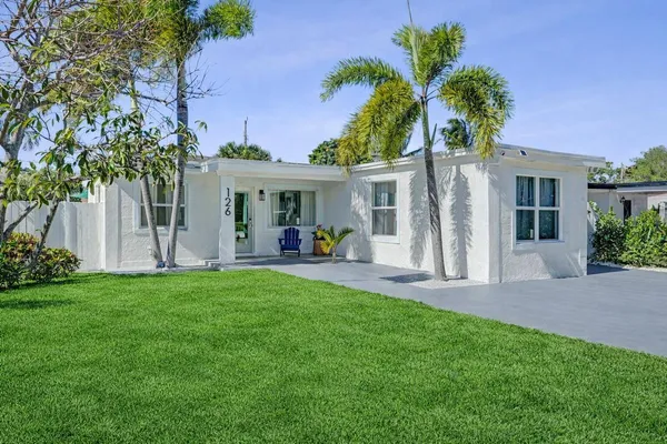 a view of a house with a yard and a patio